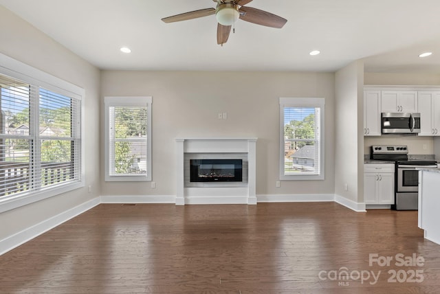 7 Lola Lilly Pl, Asheville, NC 28803 - unfurnished living room with plenty of natural light, dark wood-style flooring, ceiling fan, a glass covered fireplace, and recessed lighting
