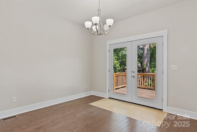 7 Lola Lilly Pl, Asheville, NC 28803 - unfurnished dining area with french doors, wood finished floors, a chandelier, and baseboards
