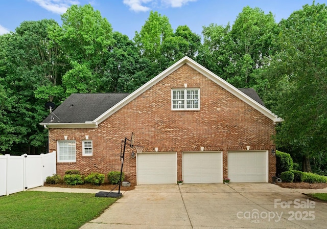 328 Whippoorwill Rd, Mooresville, NC 28117 - view of property exterior with an attached garage, driveway, brick siding, fence, and a shingled roof