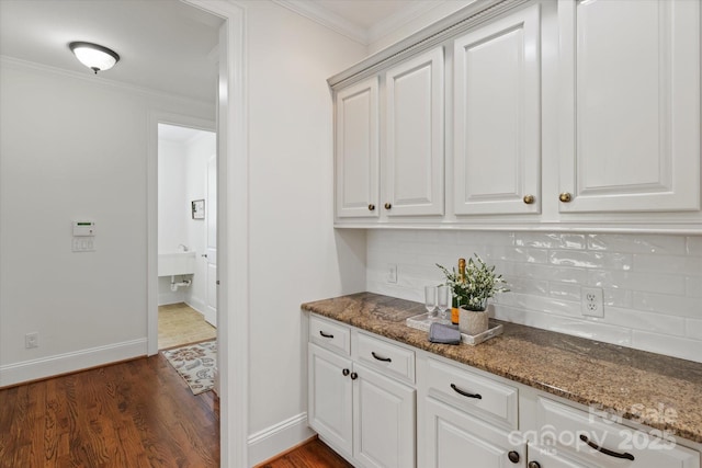 7507 Meadowgate Ln, Waxhaw, NC 28173 - kitchen with tasteful backsplash, ornamental molding, dark wood-style flooring, dark stone countertops, and baseboards
