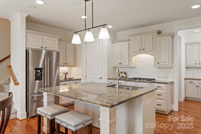 7507 Meadowgate Ln, Waxhaw, NC 28173 - kitchen featuring stainless steel appliances, a sink, stone counters, an island with sink, and ornamental molding