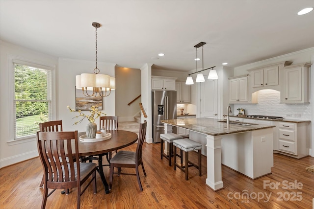7507 Meadowgate Ln, Waxhaw, NC 28173 - dining space featuring wood finished floors, baseboards, a chandelier, recessed lighting, and stairs