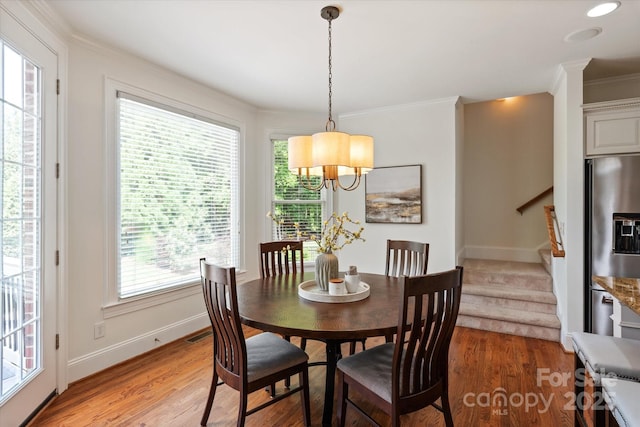 7507 Meadowgate Ln, Waxhaw, NC 28173 - dining area featuring crown molding, stairs, a chandelier, light wood-style floors, and baseboards