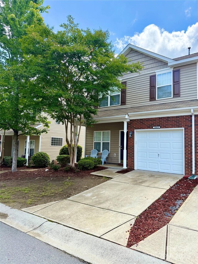 13612 Singleleaf Ln, Charlotte, NC 28278 - view of front of home with a porch, a garage, brick siding, and driveway