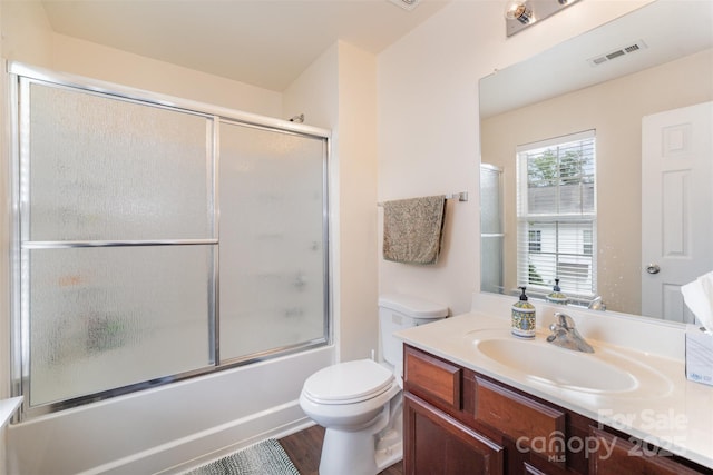 13612 Singleleaf Ln, Charlotte, NC 28278 - full bath featuring wood finished floors, toilet, vanity, and combined bath / shower with glass door