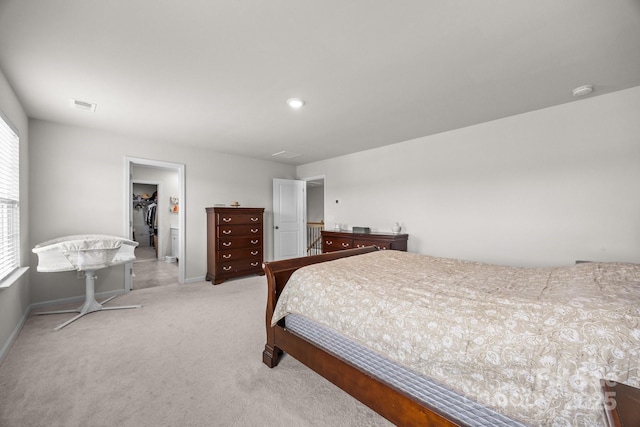 carpeted bedroom featuring a walk in closet, baseboards, and a closet