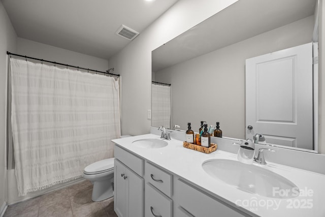 bathroom featuring toilet, tile patterned flooring, and double vanity