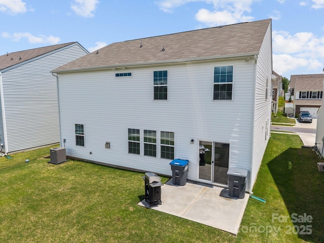 back of property with a yard, a patio, a shingled roof, and cooling unit