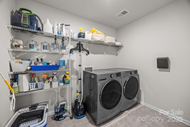 washroom featuring washing machine and dryer, baseboards, and tile patterned flooring