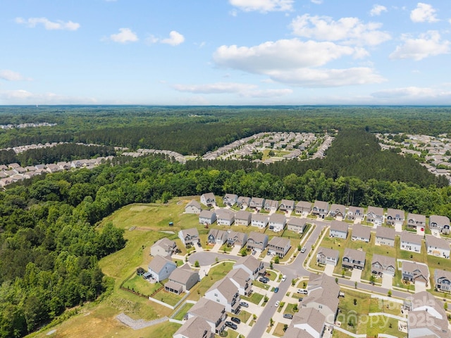 aerial view of property's location with a forest and nearby suburban area