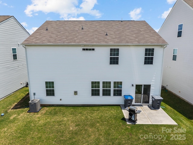back of property featuring a yard, a patio area, central AC unit, and a shingled roof