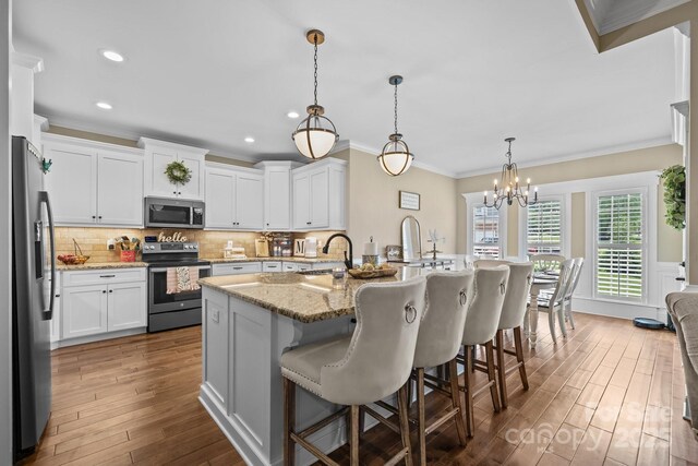 335 Wintergreen Ct, Kings Mountain, NC 28086 - kitchen with stainless steel appliances, a sink, ornamental molding, dark wood-type flooring, and a breakfast bar area