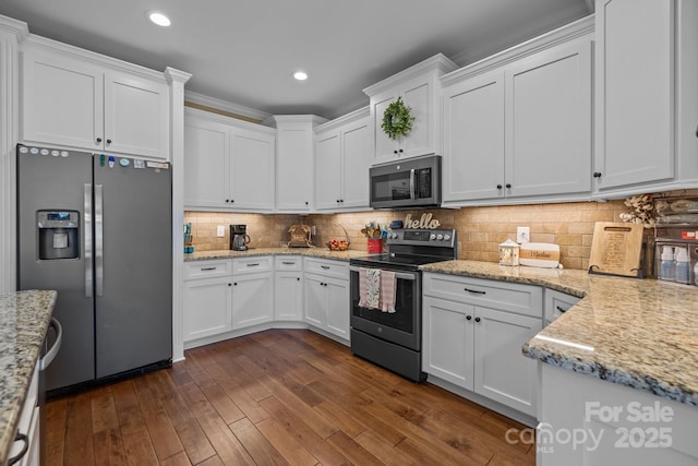 335 Wintergreen Ct, Kings Mountain, NC 28086 - kitchen featuring appliances with stainless steel finishes, white cabinets, dark wood-style floors, tasteful backsplash, and light stone counters