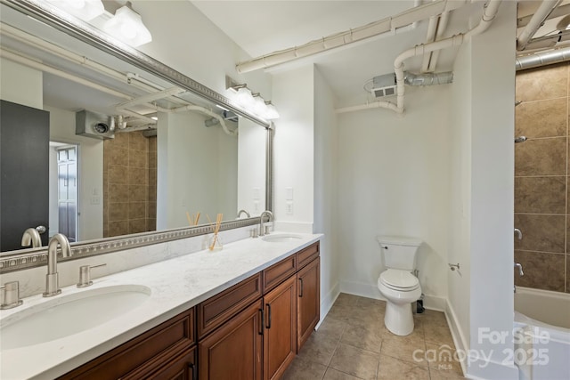 full bath featuring toilet, tile patterned floors, and double vanity