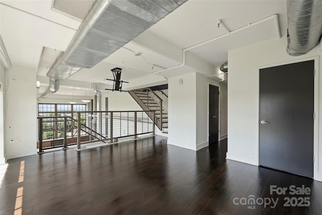 unfurnished living room with baseboards and wood finished floors