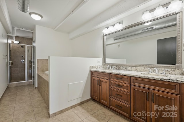 bathroom with tile patterned floors, a stall shower, a garden tub, and double vanity