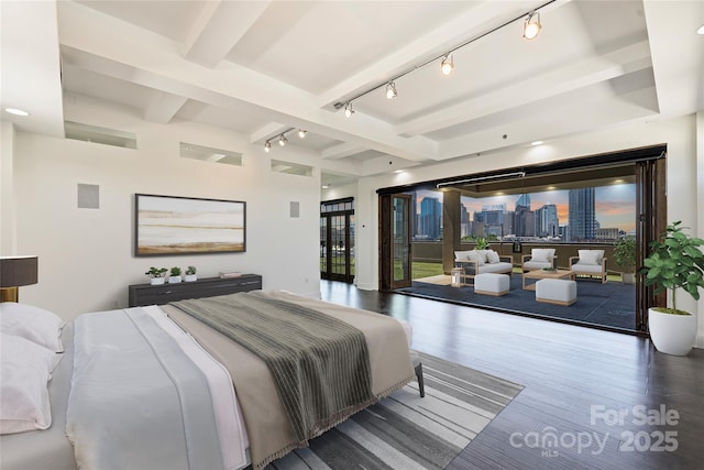 bedroom featuring rail lighting, access to outside, wood finished floors, and beamed ceiling