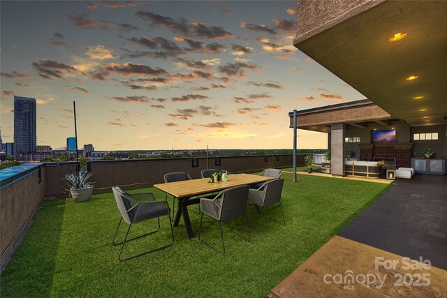 yard at dusk with a yard and a patio area