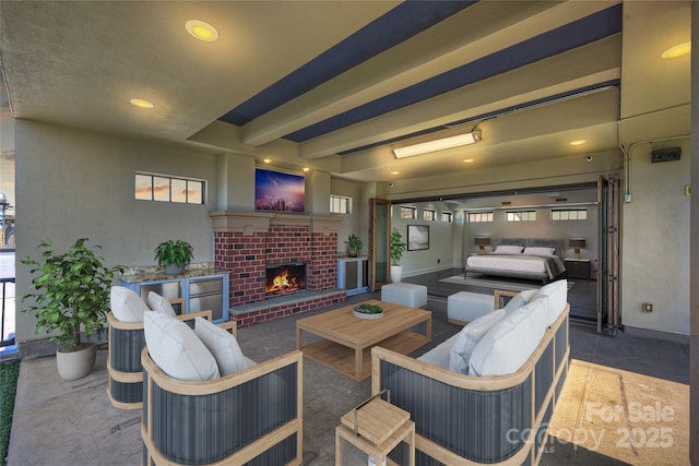 living area featuring a brick fireplace and recessed lighting