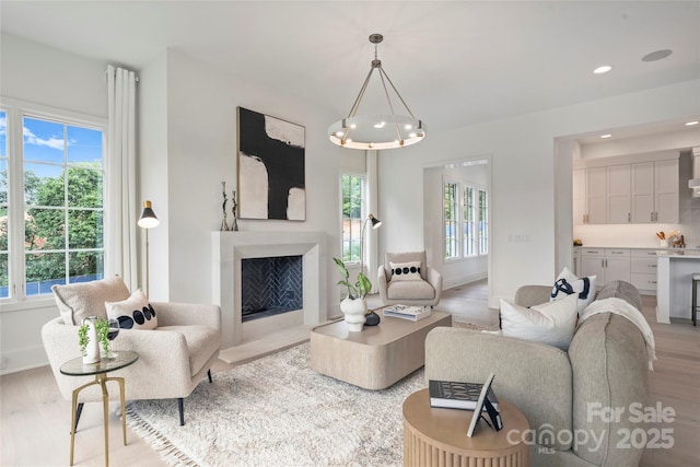 536 Hillside Ave, Charlotte, NC 28209 - living room featuring light wood-style flooring, a chandelier, a fireplace, baseboards, and recessed lighting
