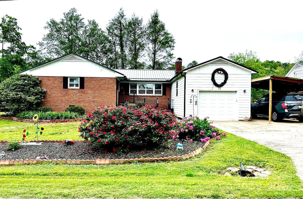 single story home with brick siding, a front lawn, a carport, driveway, and a chimney