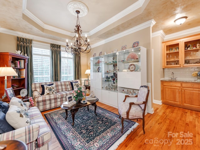3044 Luke Crossing Dr, Charlotte, NC 28226 - living area with a chandelier, light wood-style flooring, a raised ceiling, and crown molding