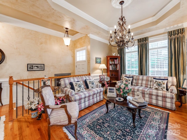 3044 Luke Crossing Dr, Charlotte, NC 28226 - living room with a chandelier, wood finished floors, crown molding, a raised ceiling, and wainscoting
