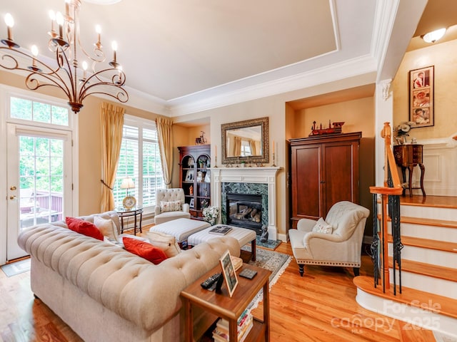 3044 Luke Crossing Dr, Charlotte, NC 28226 - living area with a chandelier, light wood-style flooring, healthy amount of natural light, a premium fireplace, and ornamental molding