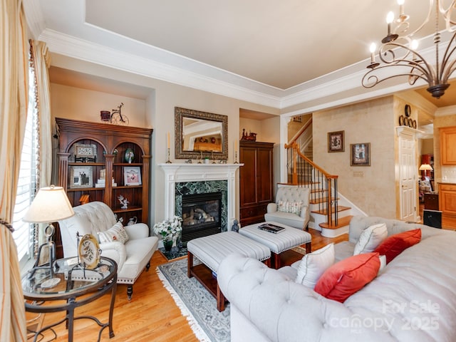3044 Luke Crossing Dr, Charlotte, NC 28226 - living area featuring crown molding, stairway, a chandelier, light wood-style flooring, and a fireplace