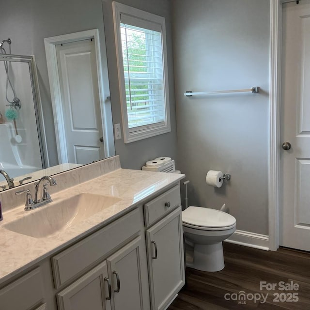 1119 Balls Creek Rd, Claremont, NC 28610 - full bath featuring wood finished floors, an enclosed shower, baseboards, vanity, and toilet