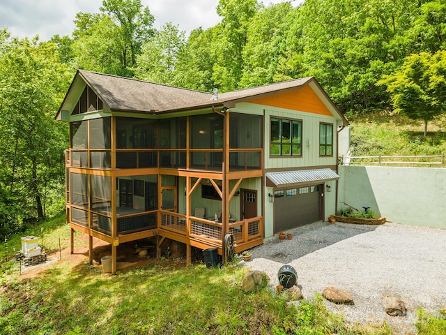 201 Ruffed Grouse Ln, Waynesville, NC 28786 - back of property with gravel driveway, a sunroom, a garage, fence, and a standing seam roof