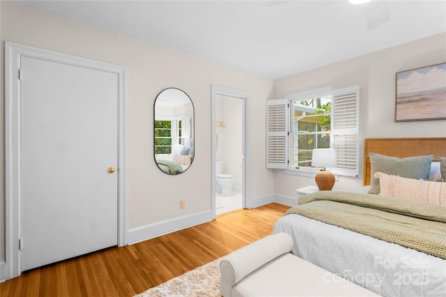5162 Lincrest Pl, Charlotte, NC 28211 - bedroom featuring wood finished floors, multiple windows, baseboards, and connected bathroom