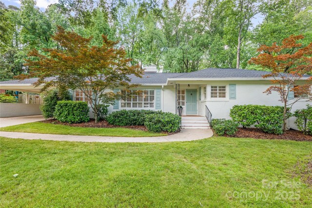 5162 Lincrest Pl, Charlotte, NC 28211 - view of front of house featuring a front yard, a carport, a chimney, brick siding, and a shingled roof