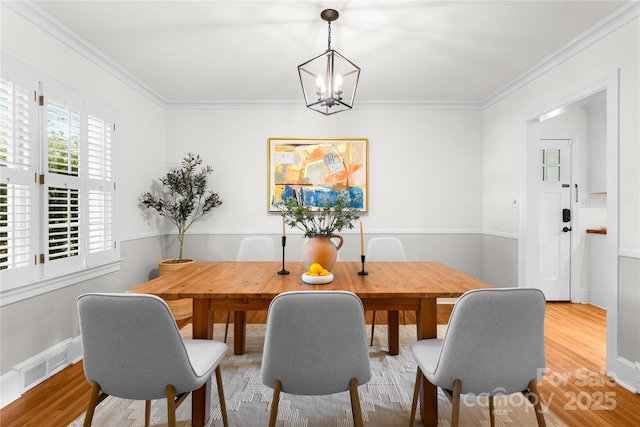 5162 Lincrest Pl, Charlotte, NC 28211 - dining space with crown molding, wood finished floors, and a chandelier