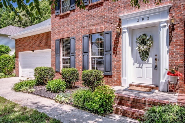 292 Rose St, Mooresville, NC 28117 - doorway to property featuring brick siding, concrete driveway, and a garage