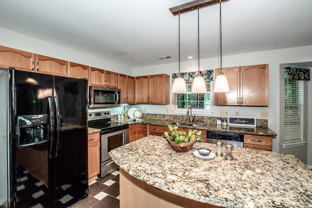 292 Rose St, Mooresville, NC 28117 - kitchen featuring stainless steel appliances, a sink, dark floors, light stone counters, and decorative light fixtures