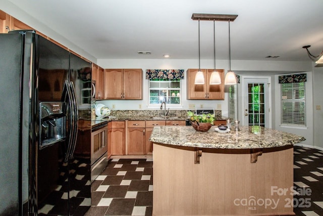 292 Rose St, Mooresville, NC 28117 - kitchen with black fridge with ice dispenser, a sink, dark flooring, a kitchen island, and a kitchen breakfast bar