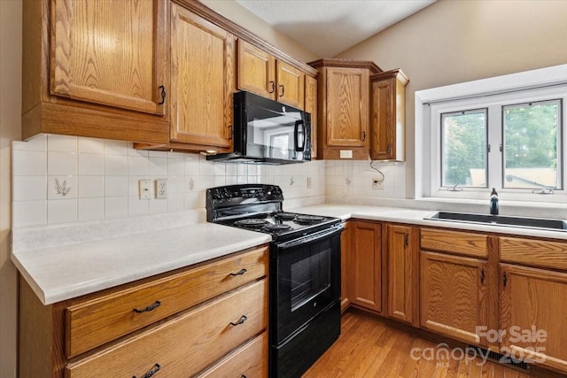305 Kyfields, Weaverville, NC 28787 - kitchen with black appliances, a sink, brown cabinets, light wood-style floors, and backsplash