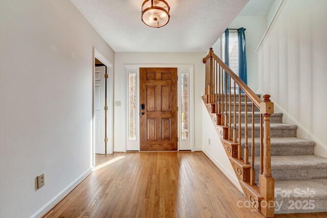 5108 Tedorill Ln, Charlotte, NC 28226 - entryway featuring light wood finished floors, stairway, baseboards, and a textured ceiling