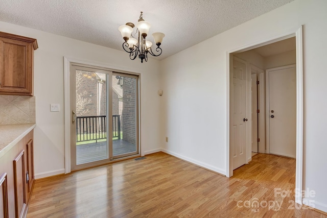 5108 Tedorill Ln, Charlotte, NC 28226 - unfurnished dining area featuring light wood finished floors, a chandelier, a textured ceiling, and baseboards