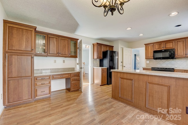 5108 Tedorill Ln, Charlotte, NC 28226 - kitchen featuring black appliances, light wood-style flooring, brown cabinets, backsplash, and glass insert cabinets