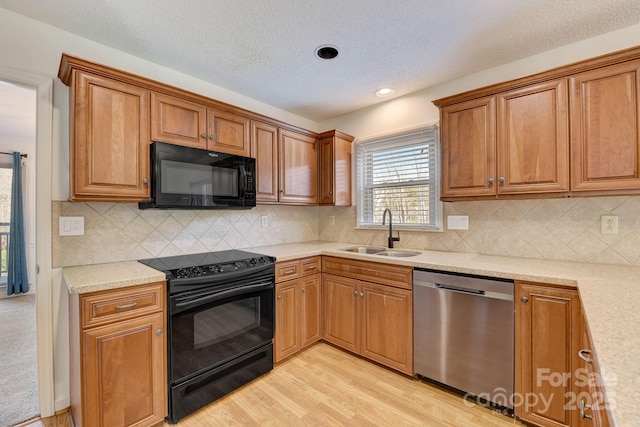 5108 Tedorill Ln, Charlotte, NC 28226 - kitchen featuring a sink, black appliances, light wood-style floors, brown cabinetry, and a textured ceiling
