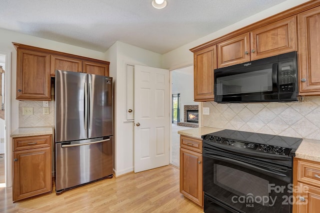 5108 Tedorill Ln, Charlotte, NC 28226 - kitchen with black appliances, brown cabinetry, and light wood-style flooring
