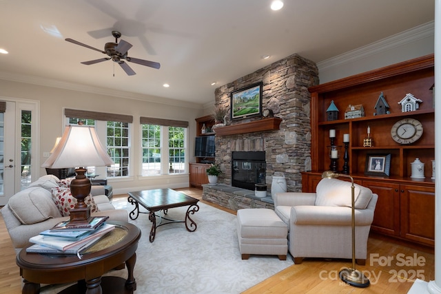 154 Pattersons Brg, New London, NC 28127 - living area with light wood-type flooring, a stone fireplace, a ceiling fan, ornamental molding, and recessed lighting