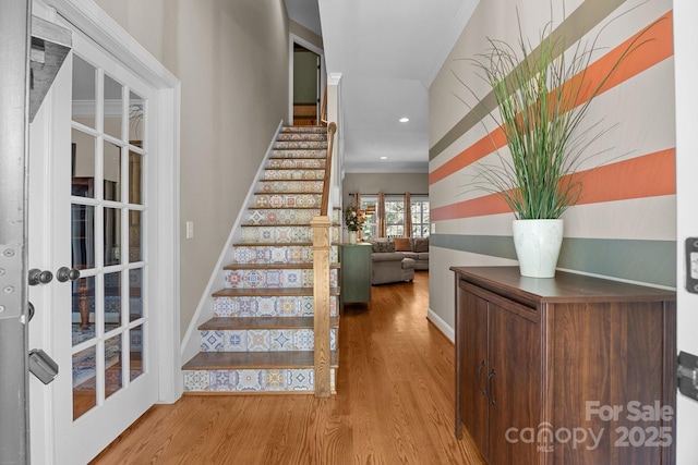 foyer with wood finished floors, stairs, baseboards, crown molding, and recessed lighting