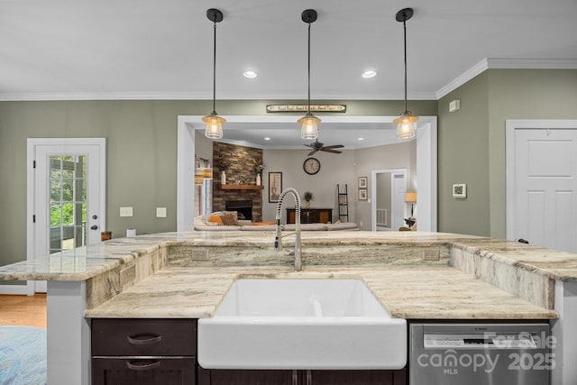 kitchen with stainless steel dishwasher, open floor plan, a sink, ceiling fan, and ornamental molding