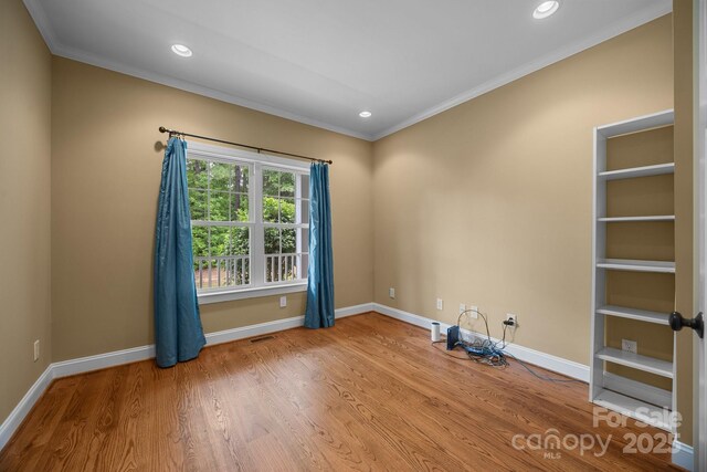 empty room with crown molding, recessed lighting, wood finished floors, and baseboards