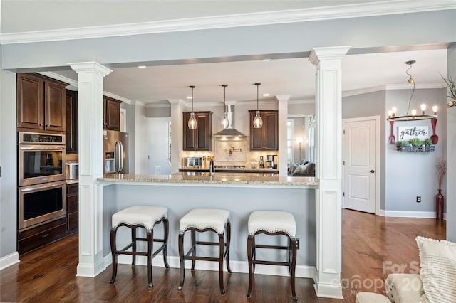 4941 Campobello Dr, Monroe, NC 28110 - kitchen with wall chimney exhaust hood, appliances with stainless steel finishes, ornate columns, and light stone countertops