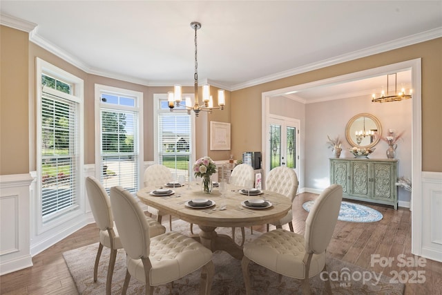 4941 Campobello Dr, Monroe, NC 28110 - dining space featuring a chandelier, wainscoting, wood finished floors, ornamental molding, and healthy amount of natural light