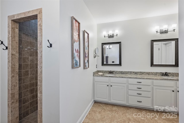 4941 Campobello Dr, Monroe, NC 28110 - bathroom featuring a tile shower, double vanity, baseboards, and tile patterned flooring